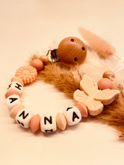 Personalisierte Schnullerkette Schmetterling mit Blume in apricot und beige, handgefertigt mit Kunststoff- oder Silikonbuchstaben
